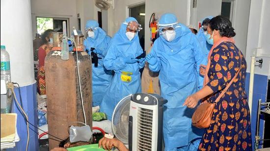 Goa chief minister Pramod Sawant (R), wearing a personal protective equipment suit, speaks to Covid-19 patients at the Goa Medical College and Hospital (GMCH), in Panjim, on May 11. (File photo)