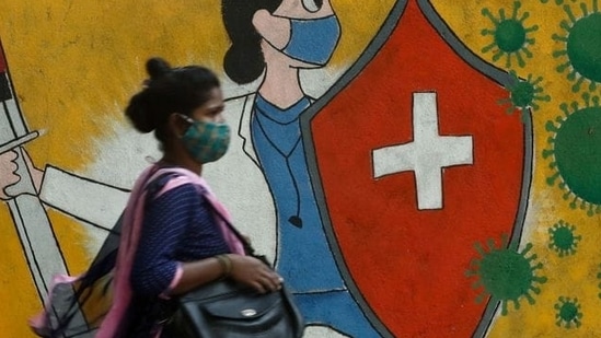 A woman walks past a graffiti on a street, amidst the spread of the coronavirus disease (Covid-19) in Mumbai.