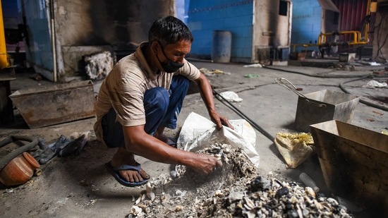 A worker collects unclaimed ashes of Covid-19 victims, at Nigambodh Ghat, in New Delhi, on May 14. At its worst, the outbreak led to 28,395 new cases on April 20 and the positivity rate touched a record 36% on April 22.(Amal KS / HT Photo)