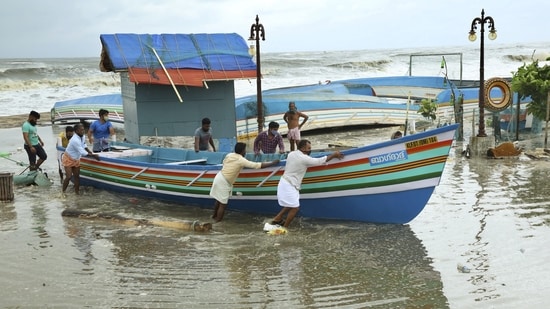 People shift fishing boats from the seashore of Kozhikode ahead of cyclone Tauktae(PTI)