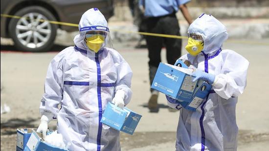 Healthcare workers wearing PPE suits carry syringes towards a Covid-19 vaccination centre in Jammu on Saturday. (PTI) Healthcare workers wearing PPE suits carry syringes towards a Covid-19 vaccination centre in Jammu on Saturday. (PTI)