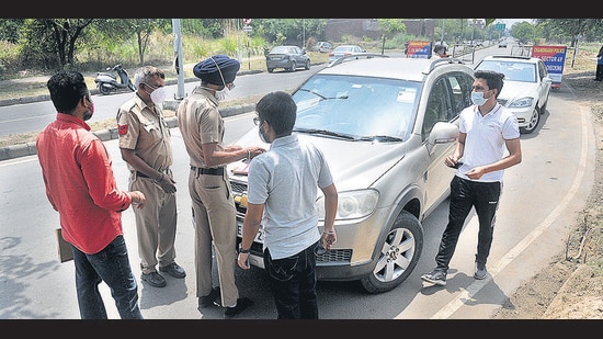 Police challaning commuters violating the weekend curfew restrictions at the entry point of Chandigarh on Saturday. (Ravi Kumar/HT) Police challaning commuters violating the weekend curfew restrictions at the entry point of Chandigarh on Saturday. (Ravi Kumar/HT)