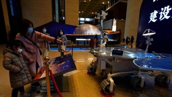 File Photo: Visitors to the National Museum look at the model of the Chinese Mars rover earlier this year in Beijing on Friday, March 12, 2021. China's first Mars rover has been named Zhurong after a traditional fire god, the government announced. (AP Photo/Ng Han Guan)