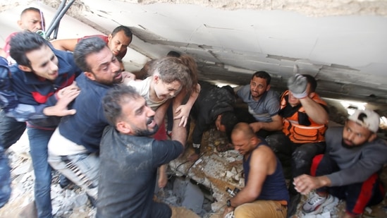 Rescuers carry a girl as they search for victims amid rubble at the site of Israeli airstrikes, in Gaza City.(Reuters)