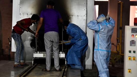 The body of a Covid-19 victim being cremated at Nigambodh Ghat crematorium, in New Delhi. (Sanjeev Verma/HT PHOTO) The body of a Covid-19 victim being cremated at Nigambodh Ghat crematorium, in New Delhi. (Sanjeev Verma/HT PHOTO)