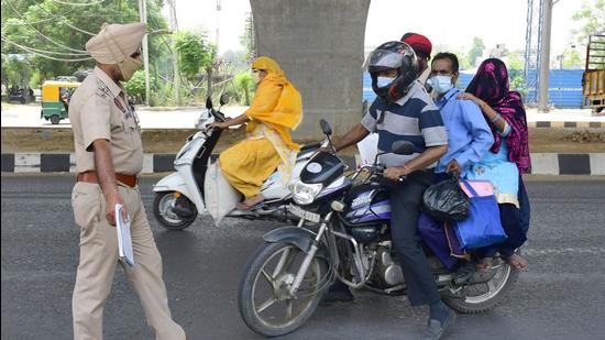 Police stopping a trio on a bike at Ferozepur Road in Ludhiana for violating traffic, and Covid protocol, according to which only one person is allowed to travel on a two-wheeler. (Harsimar Pal Singh/HT) Police stopping a trio on a bike at Ferozepur Road in Ludhiana for violating traffic, and Covid protocol, according to which only one person is allowed to travel on a two-wheeler. (Harsimar Pal Singh/HT)