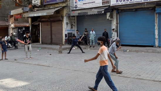 Children playing cricket during at Nabi Kareem wears a deserted look during the COVID-induced lockdown, in New Delhi. (PTI)