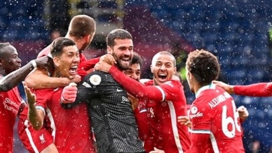 Liverpool's goalkeeper Alisson, center, celebrates with teammates after scoring his side's second goal during the English Premier League soccer match between West Bromwich Albion and Liverpool at the Hawthorns stadium in West Bromwich, England, Sunday, May 16, 2021. (AP)