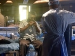 A patient breathes with the help of an oxygen mask at Shehnai Banquet Hall Covid-19 Care Centre attached to LNJP Hospital, in New Delhi on May 16. India's daily spike of coronavirus cases remained below the 3 lakh mark for the first time in nearly 26 days as only 2,81,386 fresh infections were recorded in the last 24 hours, according to the Union Health Ministry's data on May 17.(Raj K Raj / HT Photo)