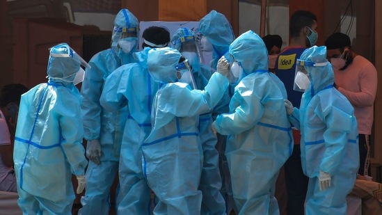 Health workers and volunteers in PPE suits wait to receive patients outside a Covid-19 hospital set up at a Gurdwara in New Delhi on May 10. The Ministry of Health and Family Welfare reported 4,106 Covid-related new deaths in the country and 3,78,741 fresh recoveries during the 24-hour period.(Ishant Chauhan / AP)