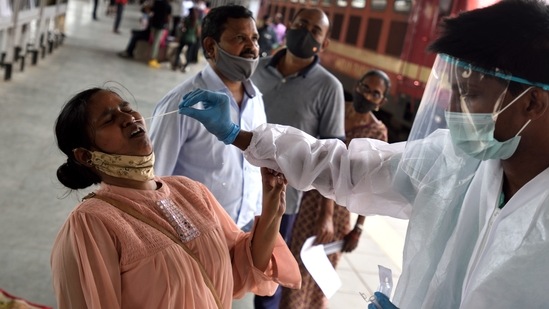 A BMC healthcare worker takes a swab sample for Covid-19 test from passengers reaching Mumbai from Uttar Pradesh, on Sunday.(Satish Bate/HT Photo)