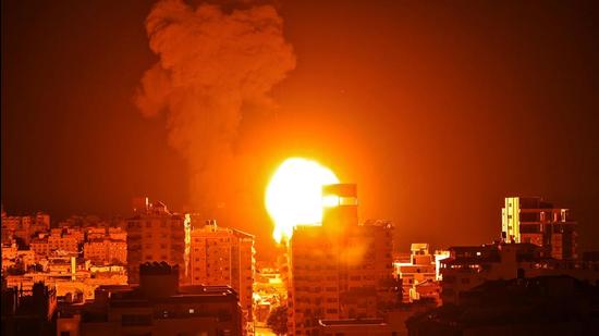 A ball of fire and a plume of smoke rise above building in Gaza city as Israeli forces shell the Palestinian enclave, early on Monday. (AFP) A ball of fire and a plume of smoke rise above building in Gaza city as Israeli forces shell the Palestinian enclave, early on Monday. (AFP)