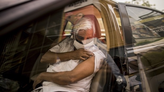 A person reacts after receiving a dose of Covid-19 vaccine at a drive-thru vaccination site set up at DLF Mall of India, in Noida on May 17. A total of 18,29,26,460 doses of Covid-19 vaccines have been administered across the country, HT reported.(Anindito Mukherjee / Bloomberg)