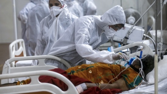 A health worker tends to a patient at the BKC jumbo field hospital, in Mumbai on May 6. On May 6, the Union Health Ministry informed that a declining trend in daily positivity rate was also observed which now stands at 16.98%.(Rafiq Maqbool / AP)