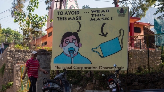A man walks past a Covid-19 awareness billboard in Dharmsala, on May 17. The Union Health Ministry also pointed out that the national recovery rate has improved to 84.25% while the mortality rate currently stands at 1.09%.(Ashwini Bhatia / AP)