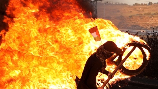 Palestinian demonstrators burn tires during a protest against the tension in Jerusalem and the Israeli-Gaza fighting. (AFP) Palestinian demonstrators burn tires during a protest against the tension in Jerusalem and the Israeli-Gaza fighting. (AFP)