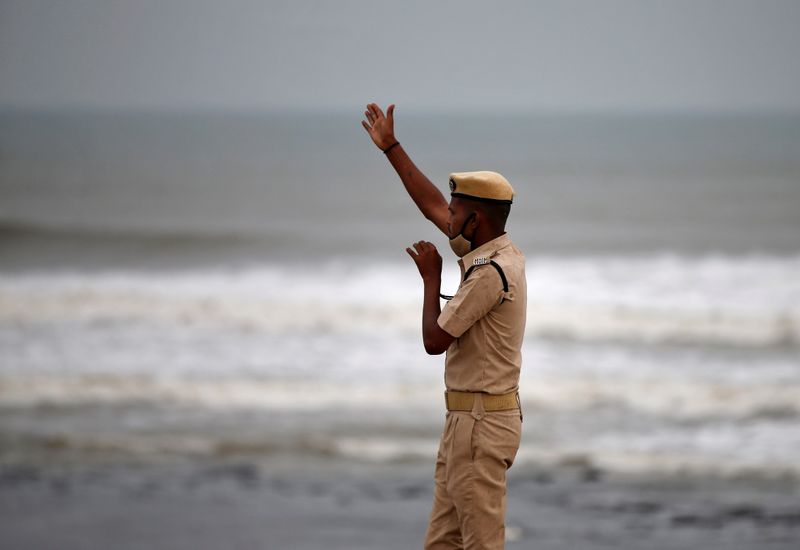 A policeman directs people to leave as waves approach the shore ahead of Cyclone Tauktae in Veraval in the western state of Gujarat on Monday. REUTERS/Amit Dave (REUTERS)