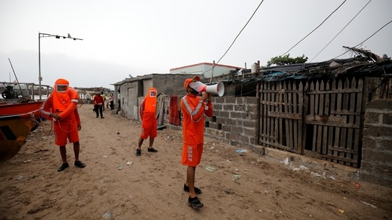 A member of the NDRF uses a megaphone to appeal to residents to move to a safer location ahead of Cyclone Tauktae’s arrival in Veraval, Gujarat on May 17. Cyclone Takutae came ashore in Gujarat with heavy rain, a battering storm surge and sustained winds of up to 165 kilometers per hour, the India Meteorological Department (IMD) said.(Amit Dave / REUTERS)