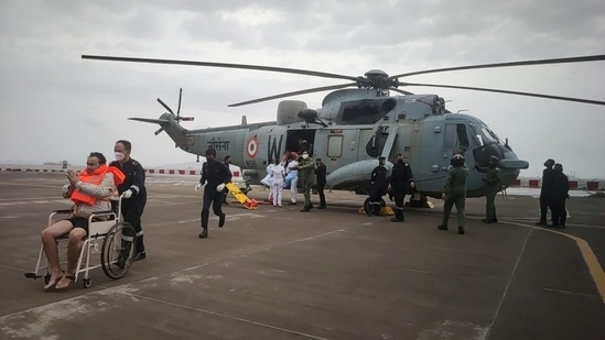 A man gestures after he was rescued by Indian Navy personnel from a sunken barge in the Arabian Sea in the aftermath of Cyclone Tauktae's landfall, at naval air station INS Shikra in Mumbai on May 18. Army personnel and other rescue teams have swung into action to clear roads and restore damaged structures.(Indian Navy via REUTERS)