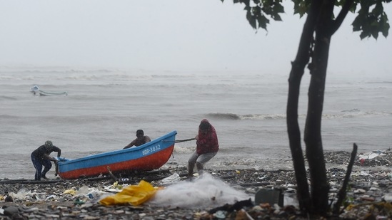 Fishermen pulling their boats ashore during the formation of cyclone Tauktae, at Bandra in Mumbai on May 17. The colossal swirling system -- the biggest to hit the region in decades – left a trail of destruction as it brushed past Kerala, Goa and Karnataka over the weekend.(Kunal Patil / PTI)