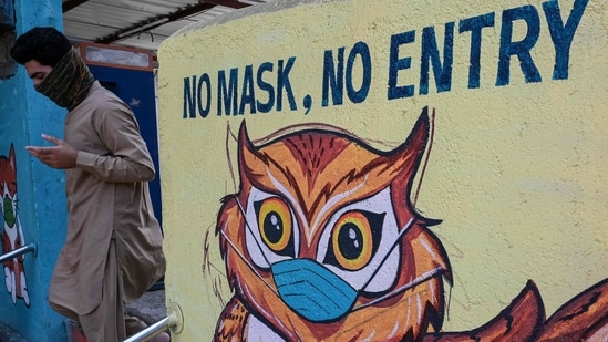 A pedestrian walks past a Covid-19 coronavirus awareness mural reading 'no mask, no entry' in Mumbai on May 12, 2021.(AFP Photo)