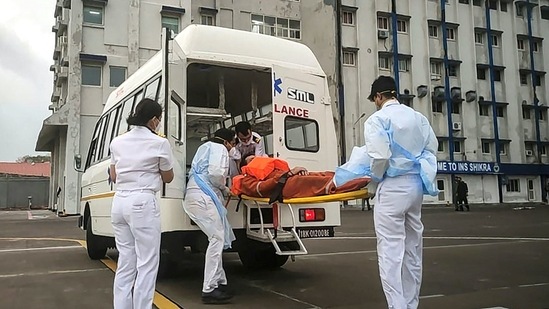 Personnel from the Indian Navy help the injured to board an ambulance for medical attention in Mumbai after Cyclone Tauktae.(AFP)