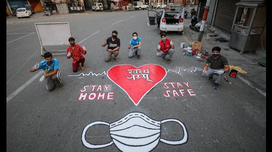 Artists of Red Cross society paint a message to spread awareness about coronavirus in Jammu on Tuesday. (PTI) Artists of Red Cross society paint a message to spread awareness about coronavirus in Jammu on Tuesday. (PTI)