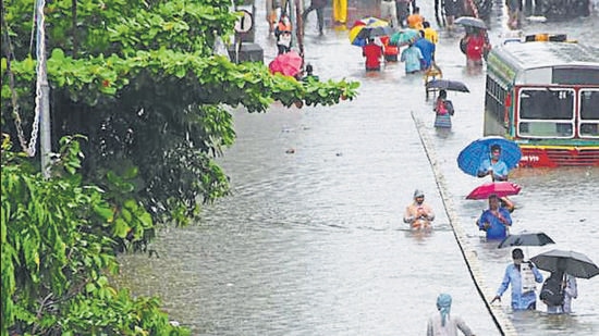 Commuters wade through a waterlogged street at Parel following heavy rainfall, in Mumbai in August, 2020. (HT archive)