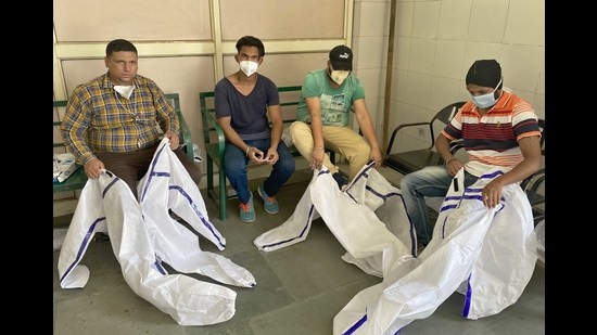 The volunteers say that cremating bodies while wearing PPE kits in the searing heat is a major challenge. Two of them had even fainted last week. (Gurpreet Singh/HT) The volunteers say that cremating bodies while wearing PPE kits in the searing heat is a major challenge. Two of them had even fainted last week. (Gurpreet Singh/HT)