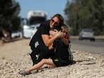 A woman protects her children as sirens sound following rocket launched from the Gaza Strip towards Israel near Sderot, Israel May 19, 2021. 