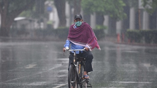 A cyclist out at Connaught Place during a spell of rain in New Delhi on May 19, 2021. (Arvind Yadav/HT Photo)