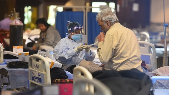 A patient being attended by a healthcare worker in Delhi Covid-19 care facility. (Raj K Raj/HT Photo) A patient being attended by a healthcare worker in Delhi Covid-19 care facility. (Raj K Raj/HT Photo)