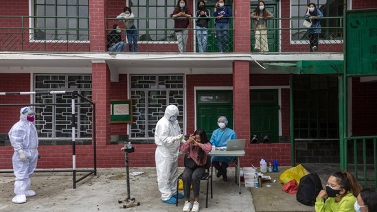 A woman reacts to her swab probe as a medical staff from the Tibetan Delek Hospital takes her sample to test for Covid-19 in the compound of a school in Dharmshala on May 18. 2,67,334 fresh infections were recorded during the previous 24-hour period taking the total tally of cases to 2,54,96,330. (Ashwini Bhatia / AP) A woman reacts to her swab probe as a medical staff from the Tibetan Delek Hospital takes her sample to test for Covid-19 in the compound of a school in Dharmshala on May 18. 2,67,334 fresh infections were recorded during the previous 24-hour period taking the total tally of cases to 2,54,96,330. (Ashwini Bhatia / AP)