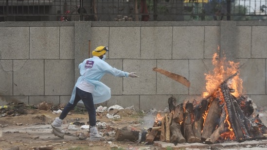 A volunteer adds wood to a funeral pyre of a Covid-19 victim at Seemapuri crematorium in New Delhi in May 18. With the latest deaths, India's official toll has at 283,248 is behind the United States on more than 600,000 deaths and Brazil with about 440,000. Experts say, however, that India's toll is much higher. (Amal KS / HT Photo) A volunteer adds wood to a funeral pyre of a Covid-19 victim at Seemapuri crematorium in New Delhi in May 18. With the latest deaths, India's official toll has at 283,248 is behind the United States on more than 600,000 deaths and Brazil with about 440,000. Experts say, however, that India's toll is much higher. (Amal KS / HT Photo)