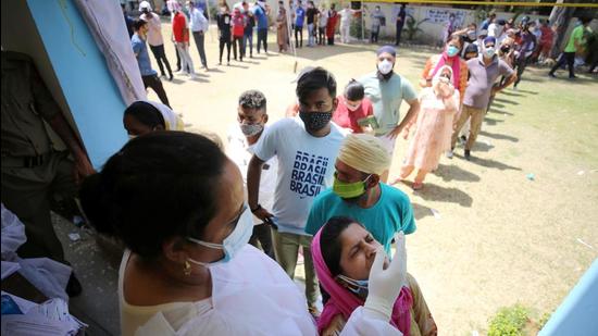 People wait in queues to give swab samples for Covid-19 tests, at a government school in Jammu on Tuesday, May 18. (PTI) People wait in queues to give swab samples for Covid-19 tests, at a government school in Jammu on Tuesday, May 18. (PTI)