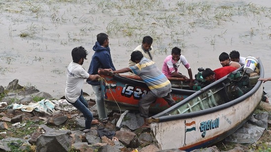 Fishermen pull fishing boats to the shore to prevent from damage from the impact of Cyclone Tauktae at Mahuva about 300 kms from Ahmedabad on May 18, 2021. (AFP) Fishermen pull fishing boats to the shore to prevent from damage from the impact of Cyclone Tauktae at Mahuva about 300 kms from Ahmedabad on May 18, 2021. (AFP)
