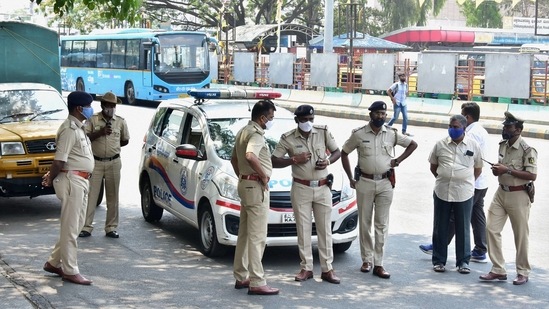 The Bengaluru police stand guard at BMTC bus stand, as coronavirus cases surge in Bengaluru, Wednesday (PTI) The Bengaluru police stand guard at BMTC bus stand, as coronavirus cases surge in Bengaluru, Wednesday (PTI)