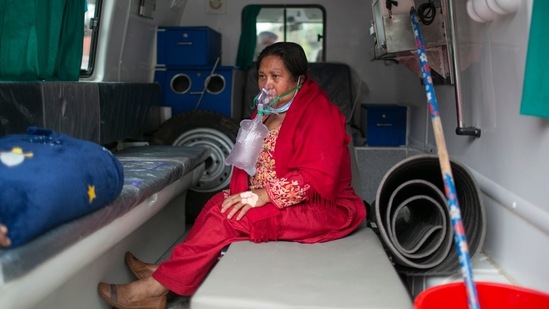 A Covid-19 patient receives oxygen in an ambulance outside an emergency ward of a hospital as she waits for a bed to be allotted at a government run hospital in Kathmandu, Nepal. (AP) A Covid-19 patient receives oxygen in an ambulance outside an emergency ward of a hospital as she waits for a bed to be allotted at a government run hospital in Kathmandu, Nepal. (AP)