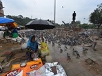 A woman selling bird feed next to a flock of pigeons while it rains at Delhi Gate in New Delhi on May 19. The maximum temperature in Delhi fell 16 degrees below normal after a day-long spell of moderate rainfall. The national capital recorded a maximum temperature of 23.8 degrees Celsius on May 19 -- the lowest maximum temperature in May for at least 70 years, HT reported.