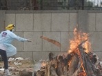 A volunteer adds wood to a funeral pyre of a Covid-19 victim at Seemapuri crematorium in New Delhi on May 18, 2021.(Amal KS / HT file photo) A volunteer adds wood to a funeral pyre of a Covid-19 victim at Seemapuri crematorium in New Delhi on May 18, 2021.(Amal KS / HT file photo)