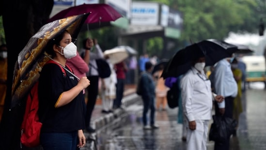 People waiting at a bus shelter near AIIMS while it rains in New Delhi on May 19. The minimum temperature as a result was 21.4°C, five degrees below the season’s normal, HT reported. (Sanjeev Verma / HT Photo)