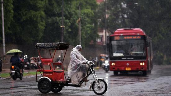 An e-rickshaw driver covers himself with a plastic sheet during rain, in New Delhi on Wednesday, May 19. (ANI) An e-rickshaw driver covers himself with a plastic sheet during rain, in New Delhi on Wednesday, May 19. (ANI)