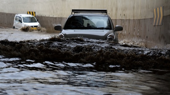 Vehicles move along a heavily waterlogged stretch at the underpass near IGI Airport T3 in New Delhi on May 19. According to IMD recordings, the May 19 temperature recording was the lowest since at least 1951 -- the year from when IMD started preserving weather recordings in a digitised format. (Sanjeev Verma / HT Photo)