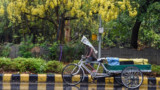A vegetable vendor pedals his cycle cart amid rain showers in New Delhi on May 19. Met officials said the all-time record rainfall for May was 60mm, logged at the Safdarjung weather observatory on May 24, 1976. (Kamal Singh / PTI)