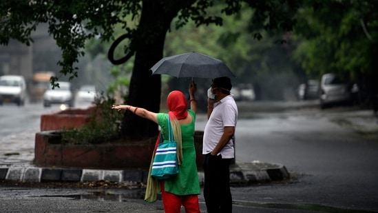 Commuters out on the road on a rainy day in New Delhi on May 19. Kuldeep Srivastava, head of IMD’s regional weather forecasting centre, said till 8.30pm on May 19, Safdarjung weather station received 60mm rainfall, Palam observatory recorded 36.8mm rain and Najafgarh station 57mm rain, HT reported. (Sanjeev Verma / HT Photo)