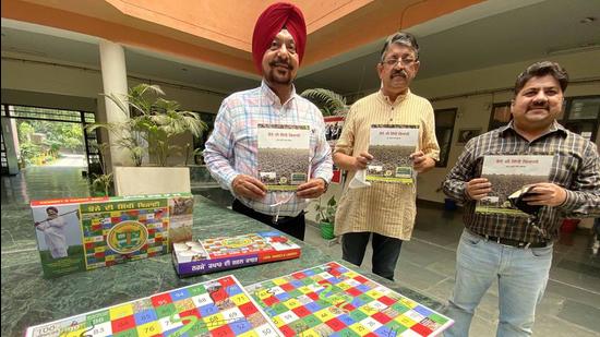 Director Tejinder Singh Riar (left) and other officials of PAU with the modified snakes and ladders board game in Ludhiana on Thursday. (Gurpreet Singh/HT) Director Tejinder Singh Riar (left) and other officials of PAU with the modified snakes and ladders board game in Ludhiana on Thursday. (Gurpreet Singh/HT)