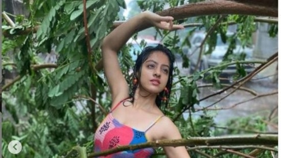 Deepika Singh Goyal poses with an uprooted tree in Mumbai.