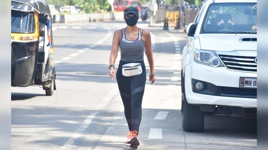 For her walk in Pali Hill, Mumbai, Mandira opted to wear a multicoloured sports bra over which she wore a basic grey spaghetti strap top.(Varinder Chawla)