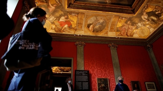 A curator talks to journalists in a period room, decorated with the ceilling from the Salons La Riviere by Charles Le Brun (1619-1690) at the Carnavalet-History of Paris Museum, located in the Marais district, during a press visit after four years of renovations in Paris, France, May 20, 2021.  (REUTERS)
