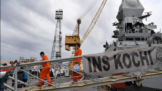 Rescued crew members of P305 disembark the INS Kochi naval ship after arriving in Mumbai on May 19. (AFP)